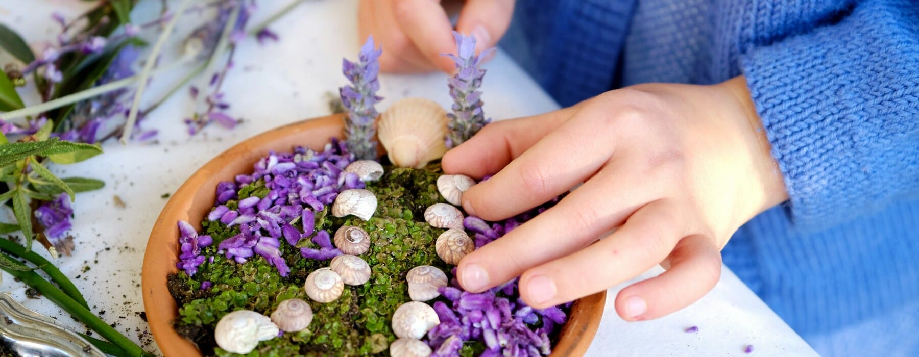 Child making miniature garden in little pot