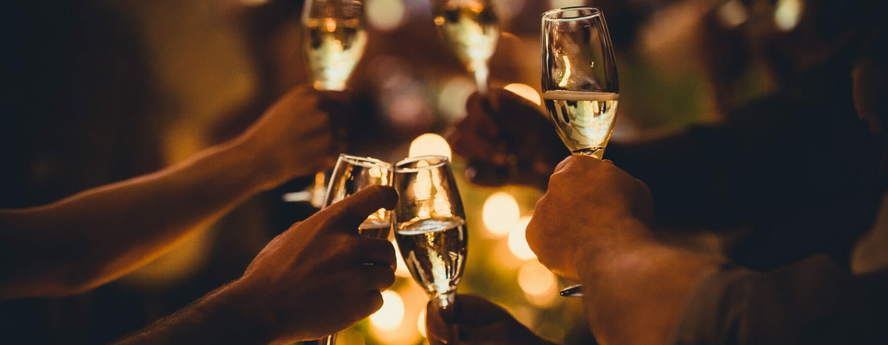 Numerous hands holding champagne flutes with champagne celebratory toast silhouettes