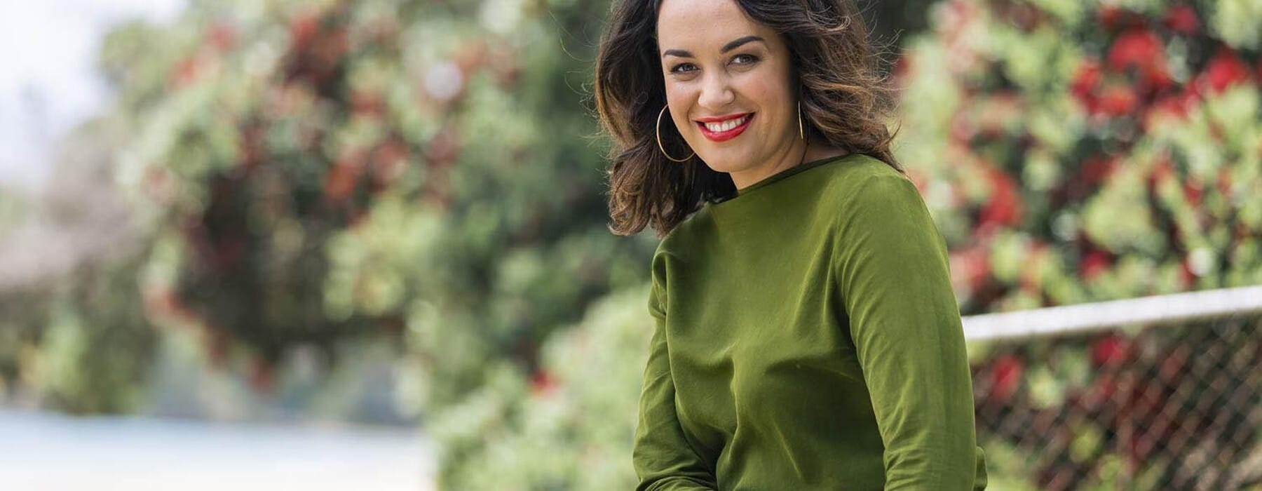 Kanoa Lloyd wearing green dress smiling at camera