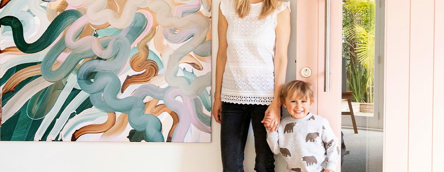 Standing-by-pink-front-door-and-art