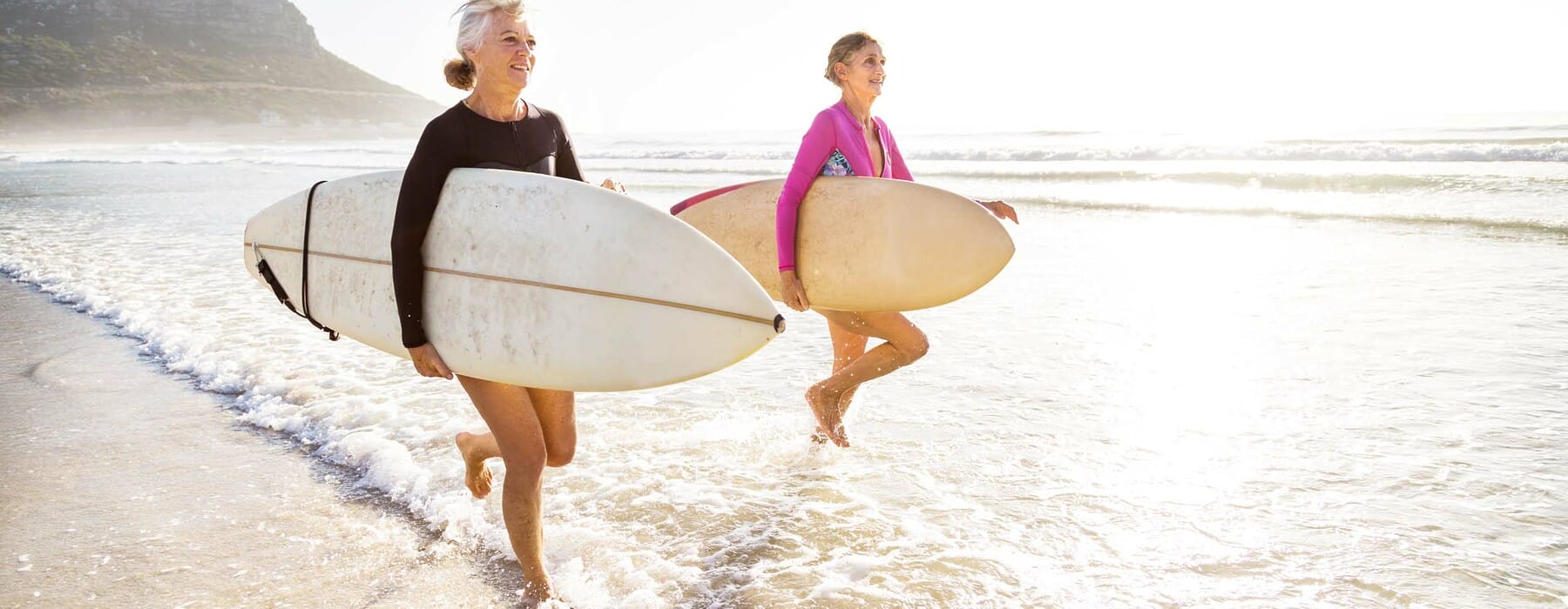 Senior women going for a morning surf in the sea