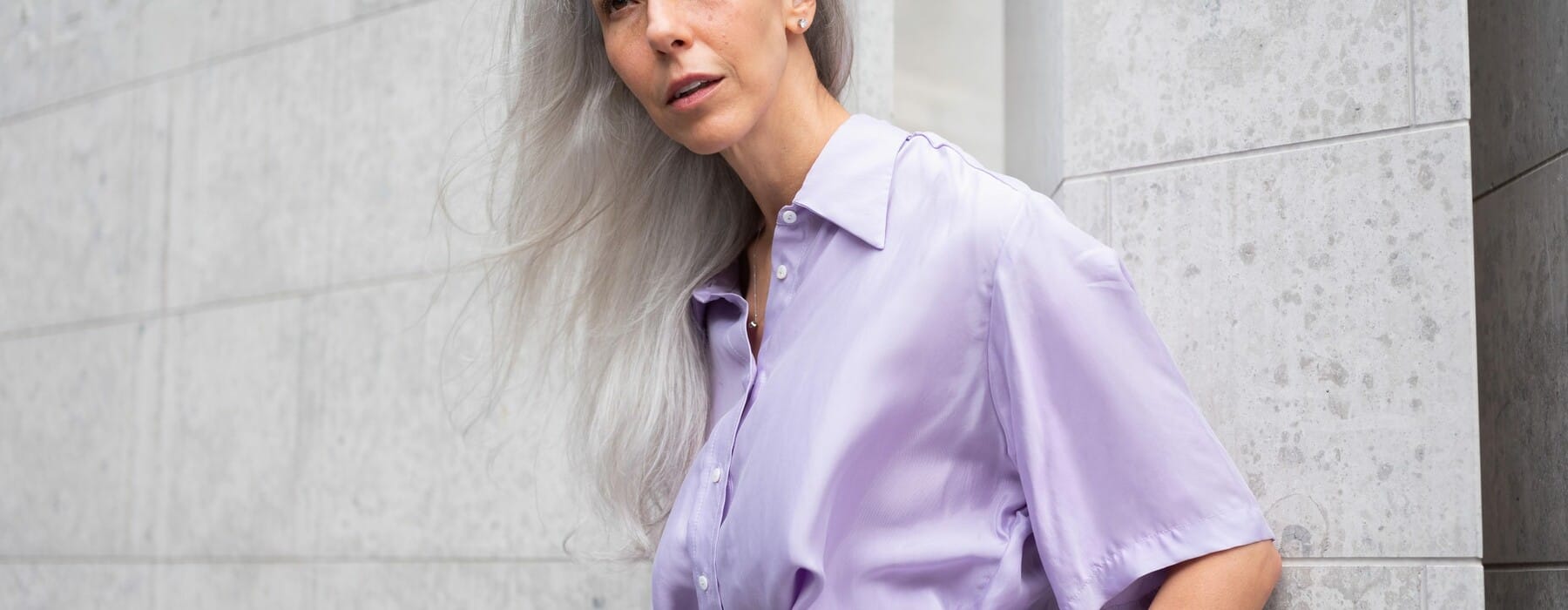 woman with white hair in a lilac shirt