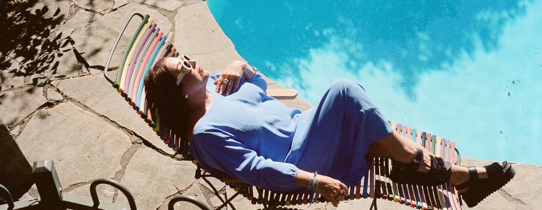 A woman lying on a recliner next to a pool