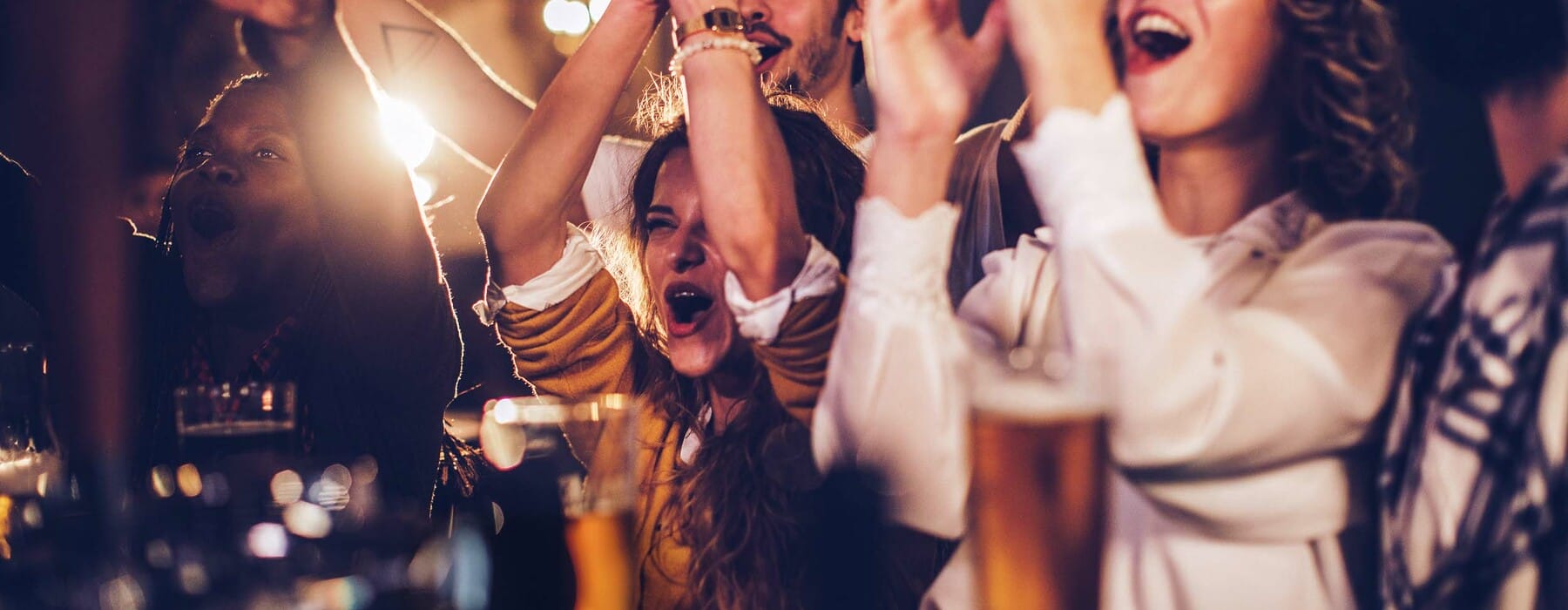 Group of friends cheering with beer in a pub