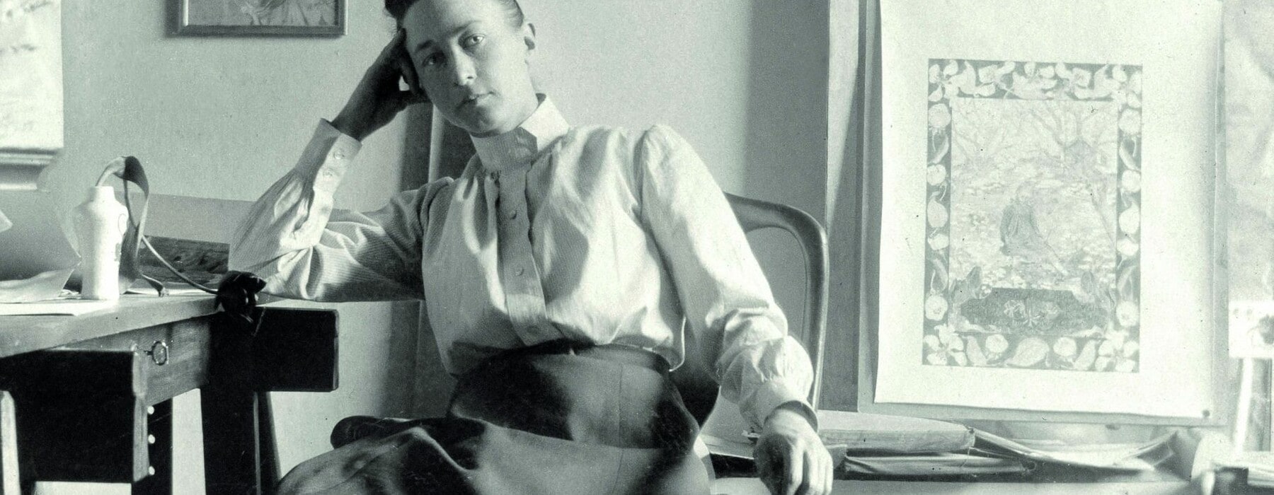 Black and white image of Hilma af Klint sitting in a chair in an art studio
