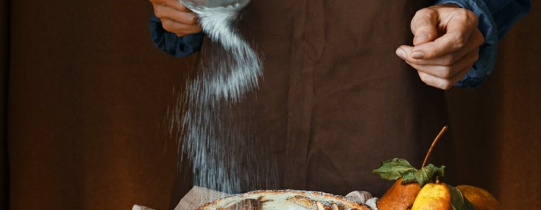 Woman sprinkling sugar on pie