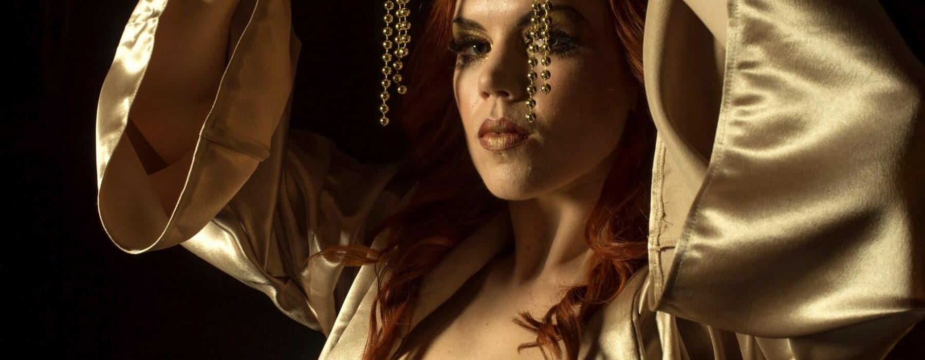 Hannah Tasker-Poland in a gold robe and paint over her nipples